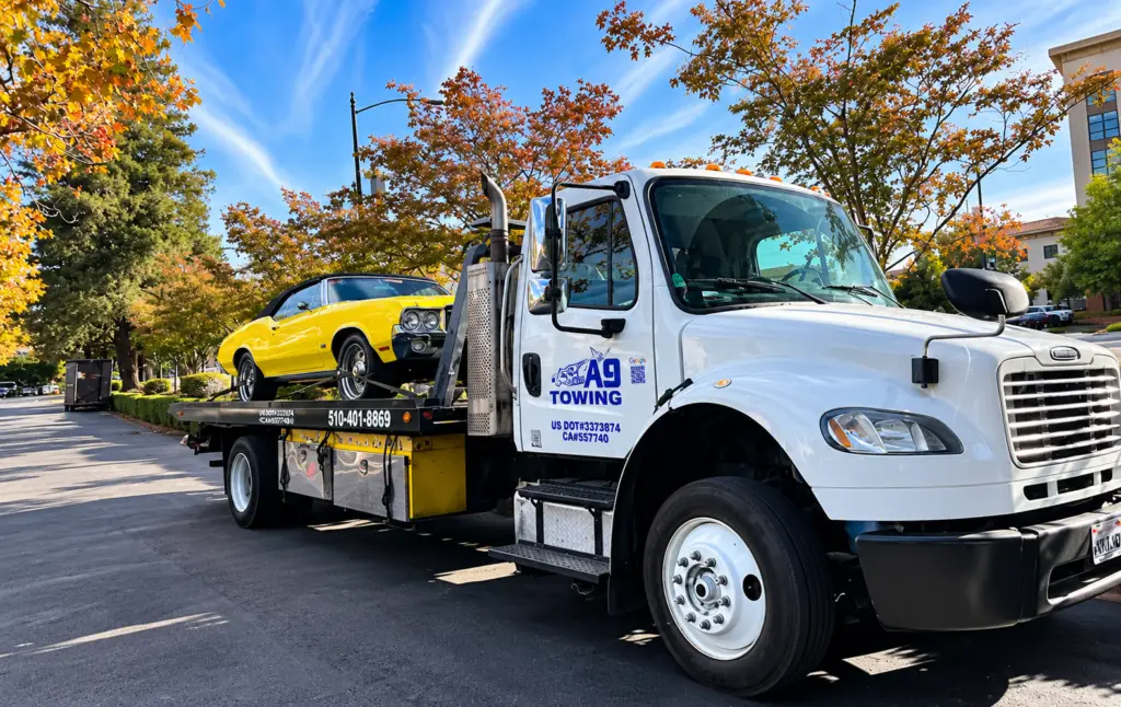 Tow truck towing a classic yellow muscle car