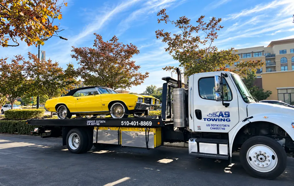 Classic convertible loaded on a flatbed tow truck